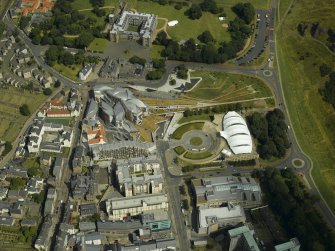 Oblique aerial view centred on the Scottish Parliament with the exhibition centre and palace adjacent, taken from the WSW.