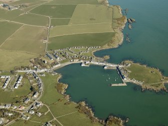 General oblique aerial view centred on the village with the tower house and remains of the promontory fort and chapel adjacent, taken from the SW.