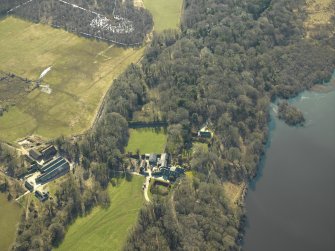 Oblique aerial view centred on the remains of the castle and crannog with the cottage and offices adjacent, taken from the NNE.