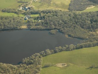 Oblique aerial view centred on the remains of the crannog with the remains of the castle, and the cottage and offices adjacent, taken from the NW.