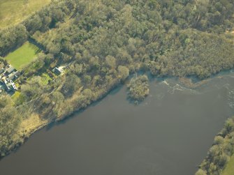 Oblique aerial view centred on the remains of the crannog with the remains of the castle, and the cottage and offices adjacent, taken from the NW.