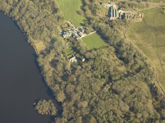 Oblique aerial view centred on the remains of the castle and crannog with the cottage and offices adjacent, taken from the SW.
