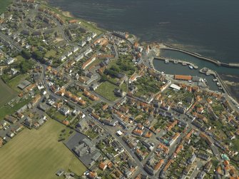 General oblique aerial view of the town centred on the harbour, taken from the NW.