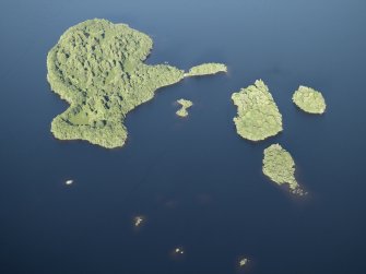 Oblique aerial view centred on the remains of the crannog and the islands, taken from the WSW.