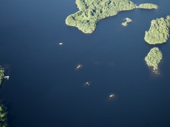 Oblique aerial view centred on the remains of the crannog and the islands, taken from the SW.