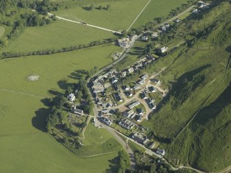 General oblique aerial view of the village, centred on the church, churchyard, burial ground, museum and the remains of the cairn with the tower-house adjacent, taken from the SE.