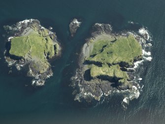 Oblique aerial view of the islands centred on the remains of the castles, taken from the NW.