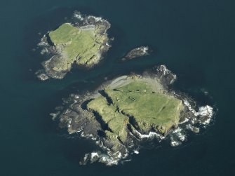 Oblique aerial view of the islands centred on the remains of the castles, taken from the W.