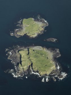 Oblique aerial view of the islands centred on the remains of the castles, taken from the WSW.