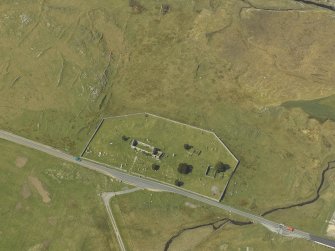 Oblique aerial view centred on the graveyard and the remains of the church, taken from the SE.