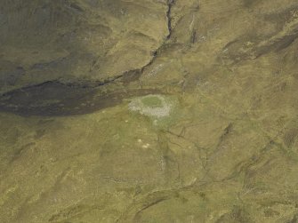 Oblique aerial view centred on the remains of the dun, taken from the SW.