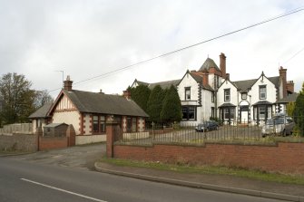View showing hotel, cottage, wall and gateway