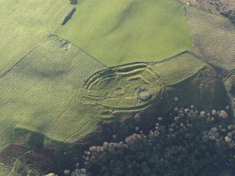 Oblique aerial view of the remains of the fort, settlement and broch at Edin's Hall and the adjacent settlement, taken from the NE.