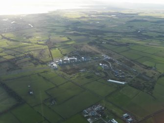 General oblique aerial view centred on the airfield with the Nuclear Power Station adjacent, taken from the E.