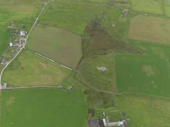 Oblique aerial view centred on the remains of Cubbie Roo's castle with the chapel adjacent, taken from the NE.