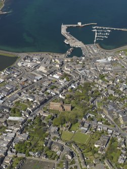 General oblique aerial view of Kirkwall centred on St Magnus' Cathedral with the harbour beyond, taken from the S.