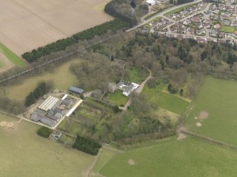 Oblique aerial view centred on the country house with the tower-house adjacent, taken from the SW.