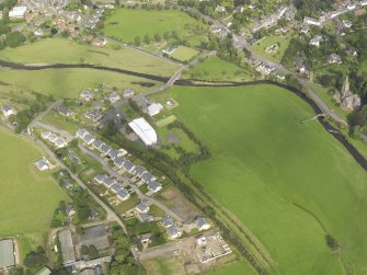General oblique aerial view centred on the former railway station with the housing estate adjacent, taken from the SW.