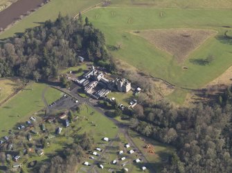Oblique aerial view centred on the country house with the caravan park adjacent, taken from the SW.