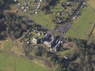 Oblique aerial view centred on the country house with the caravan park adjacent, taken from the NE.