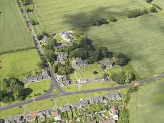 Oblique aerial view of Dalmeny centred on St Cuthbert's Church, taken from the S.