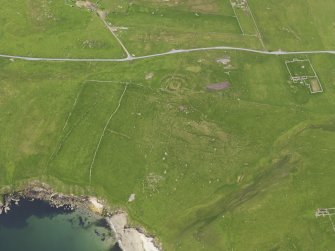 Oblique aerial view of the Broch of Underhoull and the field systems, looking ENE.