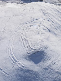 Oblique aerial view of Woden Law fort and linear earthworks in snow, looking S.