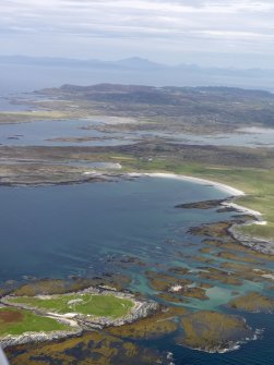 Oblique aerial view of the W coast of Oronsay, looking towards Colonsay and Mull, taken from the SW.