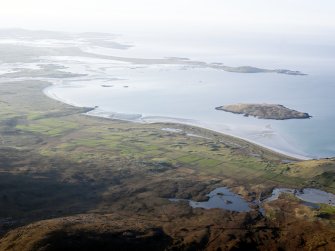 General oblique aerial view of the remains of Dun an Sticer, the remains of the township of Clachan Ard and the nearby head dyke, field system and lazy beds at Port nan long, North Uist, taken from the ESE.