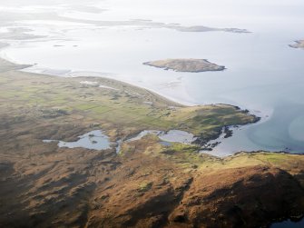 General oblique aerial view of the remains of Dun an Sticer, the remains of the township of Clachan Ard and the nearby head dyke, field system and lazy beds at Port nan long, North Uist, taken from the E.