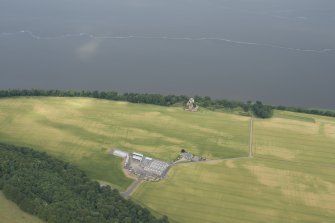Oblique aerial view of Ballinbreich Castle and farmstead, with the cropmarked field in between, looking N.