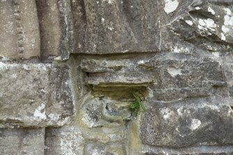 Detail of east weathered corbel to middle order of door archway.