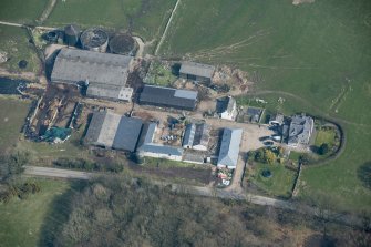 Oblique aerial view of Auchenskeock Castle and Farm, looking NE.