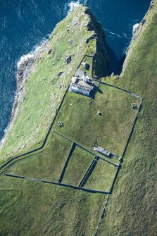 Oblique aerial view of Barra Head Lighthouse, the field boundaries and the possible dun, looking SW.