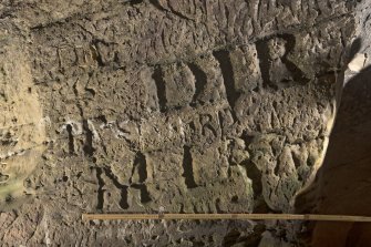 Detail of carved lettering on south wall of cave (including scale)
