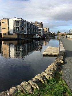 General view along Union Canal showing kerbstones in foreground, former Leamington Wharf, and new development at Ropewalk, Leamington Road, Edinburgh.