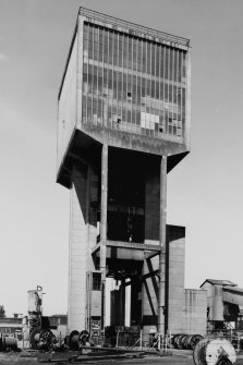 General view from S of no. 1 shaft winding tower, Monktonhall Colliery, built from re-inforced concrete, used to wind coal and men using two tower-mounted, geared, multi-rope A.C. friction winders with skip and counterweight, both manually controlled and equipped with dynamic braking.  No. 1 shaft is also the upcast air shaft.
