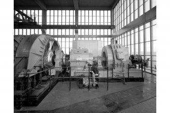 Detail on top floor of no. 1 shaft tower showing (right to left) the exciter, electronic motor, gearbox and cable drum of the 1B winder.  Each of the two winders is equipped with 14-tonne skips, and are together designed to lift 430 tonnes of coal per hour.  The counterweights have rope guides.