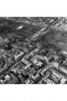 Oblique aerial view of centre of Edinburgh including Princes Street at top of photograph, Waverley Bridge to right, Parliament Square, High Court of Justiciary to bottom and Castlehill to left