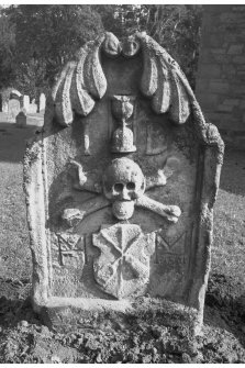 Humbie churchyard.
James Dobbie d.1679. Stylised leaves curling over top of stone. Hourglass between initials I D. Skull on crossbones. Tools of maltman on a shield between intials M M.