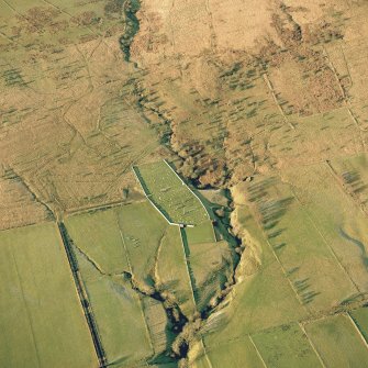 Oblique aerial view of Ettleton Sike centred on a burial-ground with the remains of a building, field-system, rig, sheepfold, hut and enclosure adjacent, taken from the SE. Digital image of D/24602/CN.