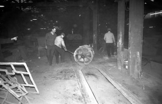 Interior
View showing men working iron ladle