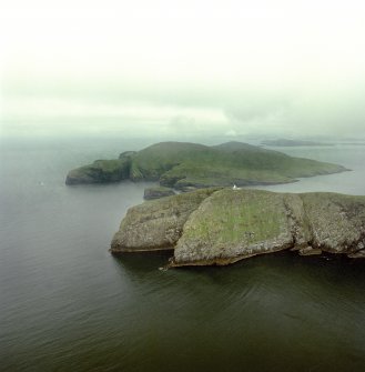General oblique aerial view of the lighthouse with the island of Mingulay and those to the N in the background, taken from theS .