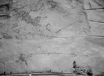 Oblique aerial view centred on the remains of the Roman temporary camp and cairnfield at Raedykes and Garrison Hill, looking to the E.