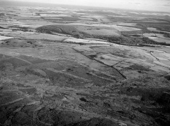 Oblique aerial view centred on the remains of the Roman temporary camp and cairnfield at Raedykes and Garrison Hill, looking to the SSW.