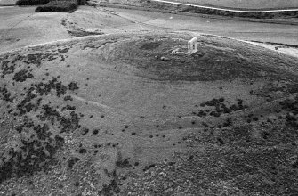 Oblique aerial view centred on the remains of the tower house and fort at Dunideer, looking to the SSE.
