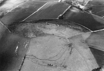 Oblique aerial view centred on the remains of the tower house and fort at Dunideer, looking to the N.