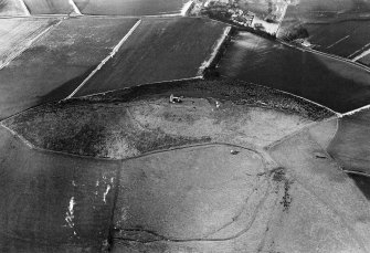 Oblique aerial view centred on the remains of the tower house and fort at Dunideer, looking to the NNE.