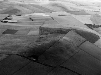 Oblique aerial view centred on the remains of the fort at Hill of Newleslie, looking to the E.