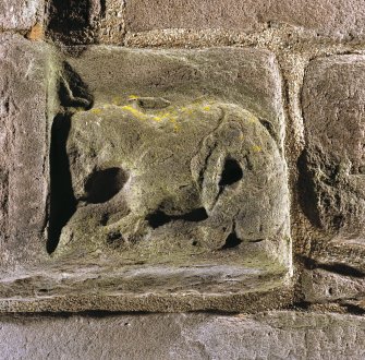 Detail of zoomorphic figure at bottom right hand corner of doorway on W side of tower.